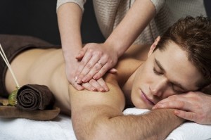 Masseur doing back massage on man body